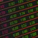 Close-up of a digital stock market data display showing colorful financial numbers and trends.